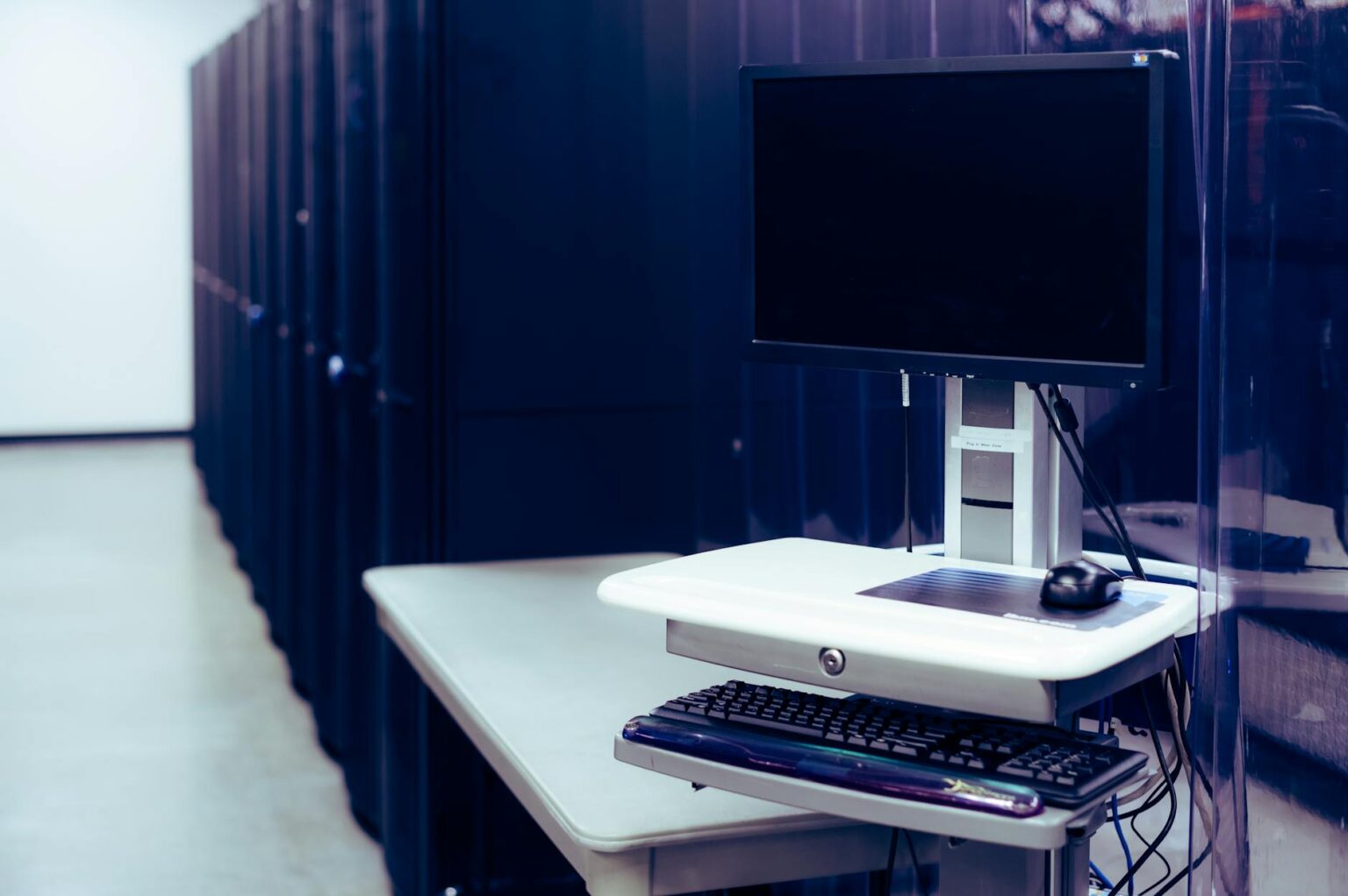 Modern data center server room with rows of computing equipment and blue lighting