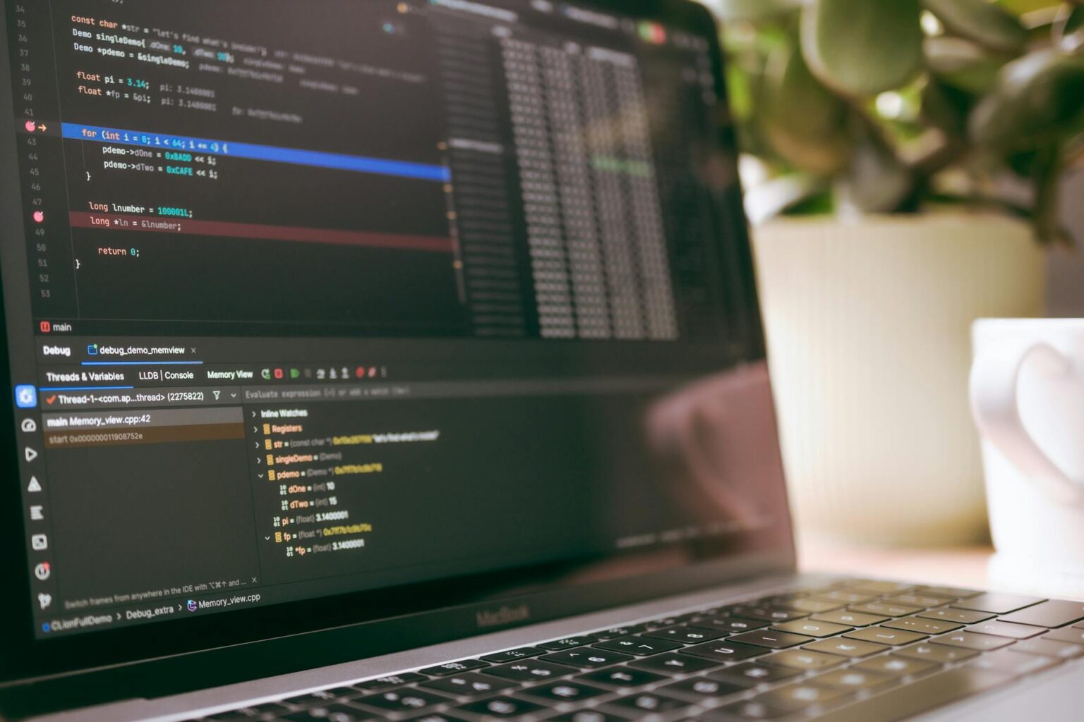Developer workspace with laptop showing code on screen in modern office environment