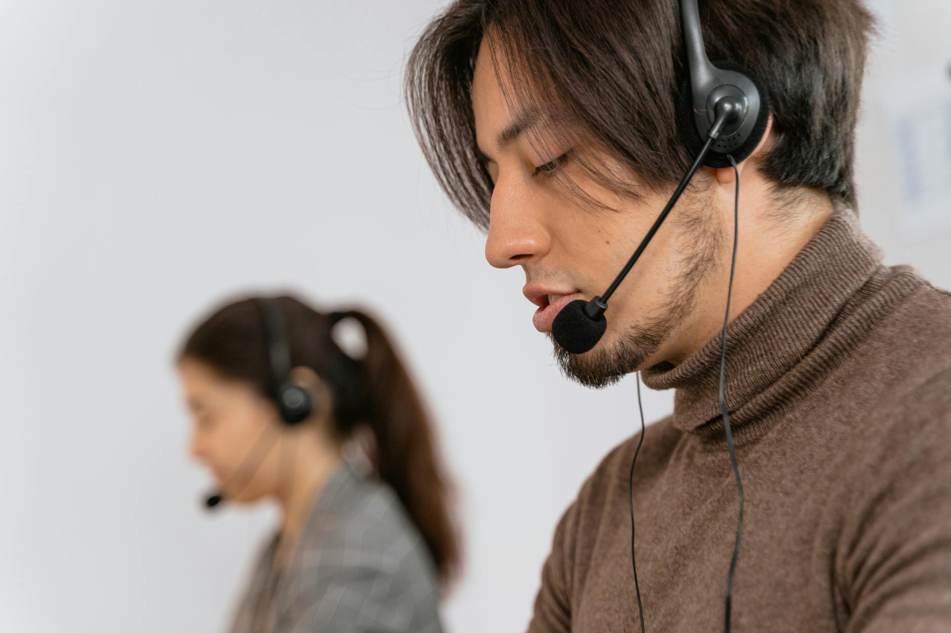Customer service representative wearing headset at computer workstation