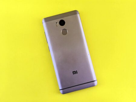 Close-up of finger touching smartphone fingerprint sensor for biometric authentication