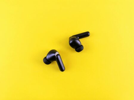 Modern wireless earbuds displayed on clean surface showing sleek design and charging case