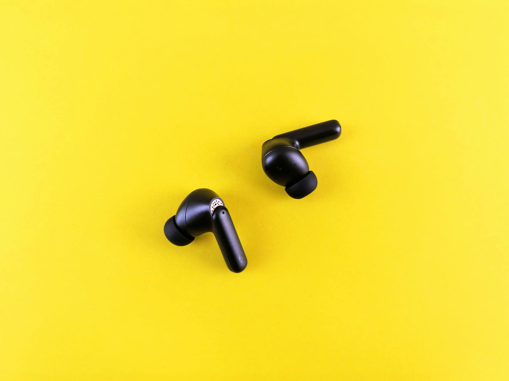 Modern wireless earbuds displayed on clean surface showing sleek design and charging case