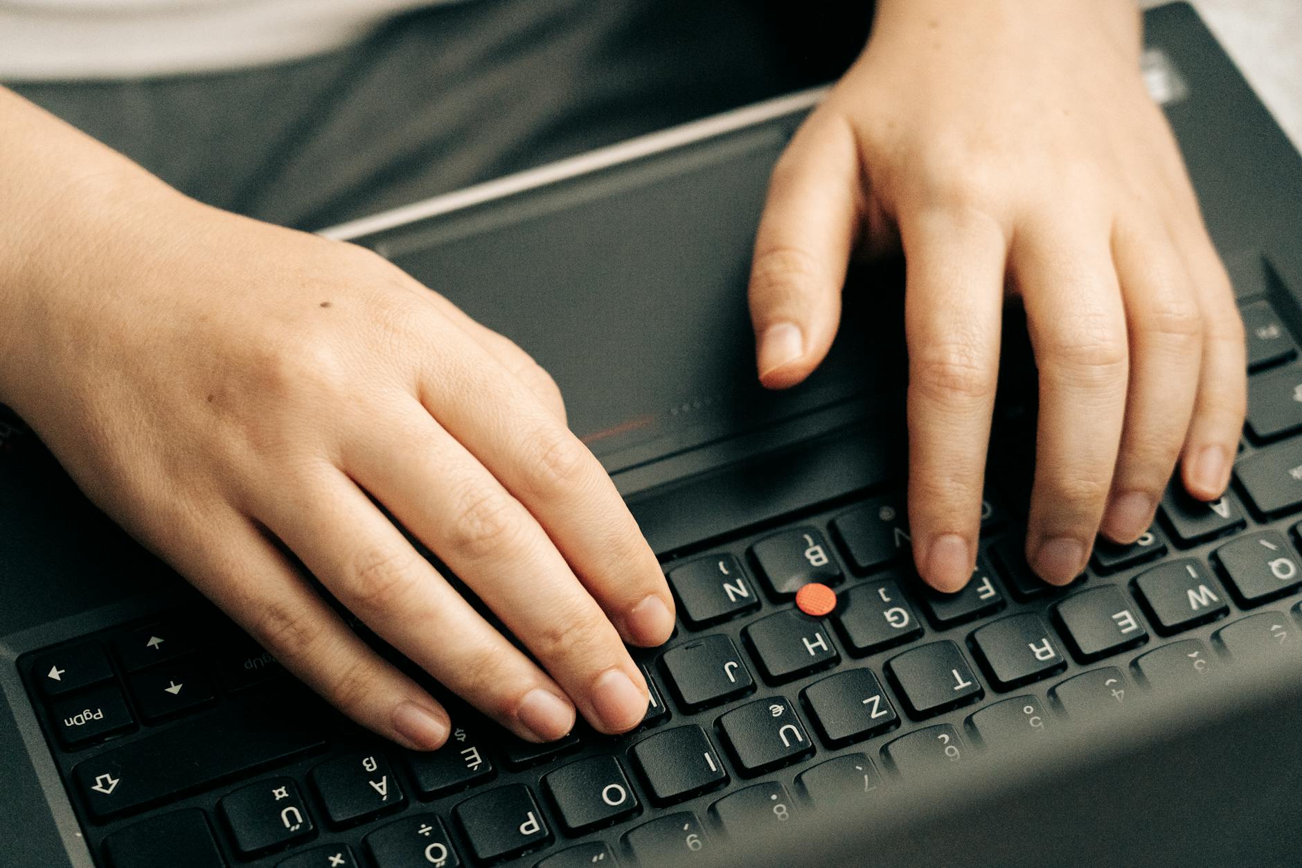 Close-up view of hands typing on modern tablet keyboard attachment