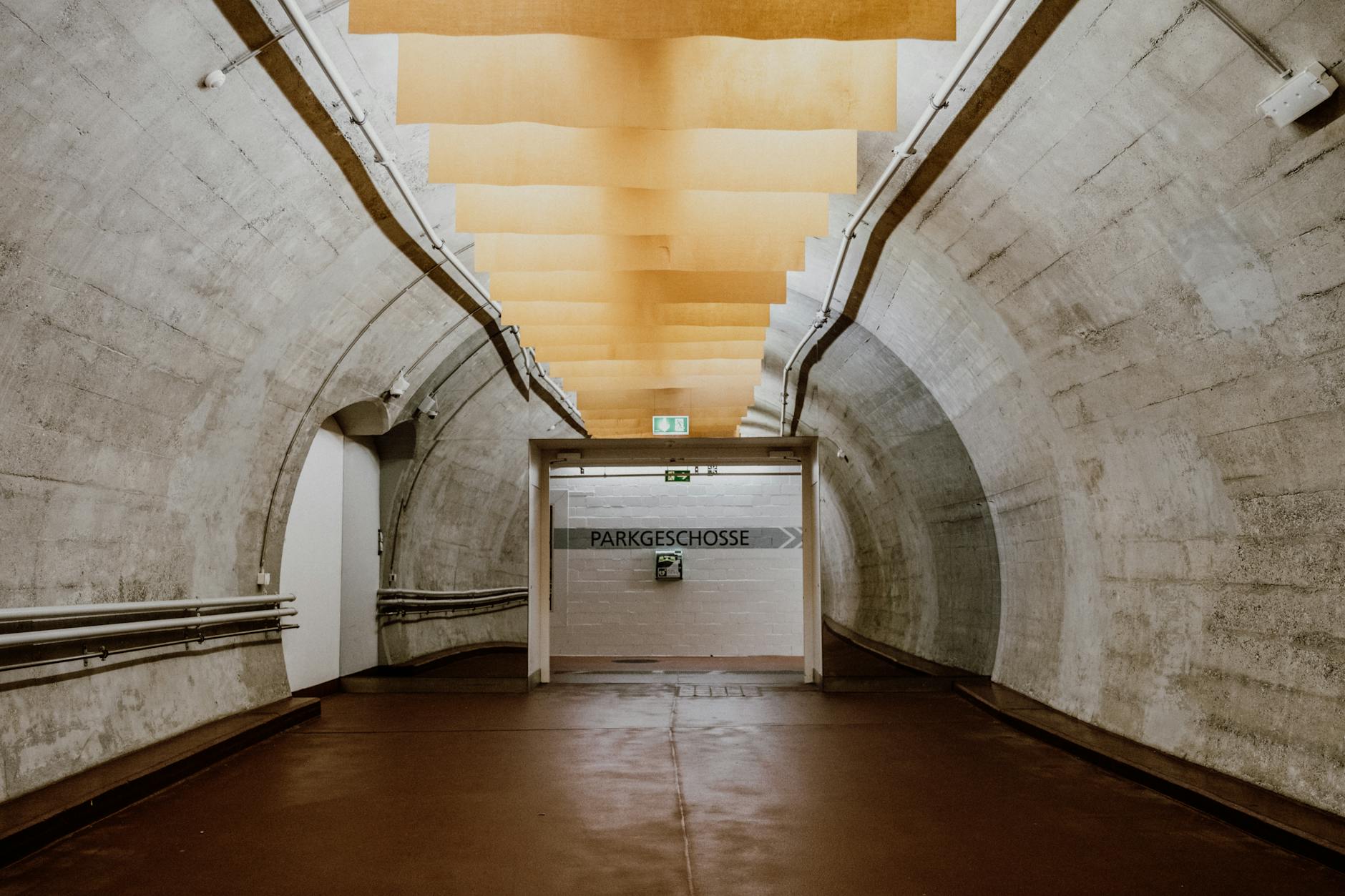Industrial underground tunnel with concrete walls and overhead lighting