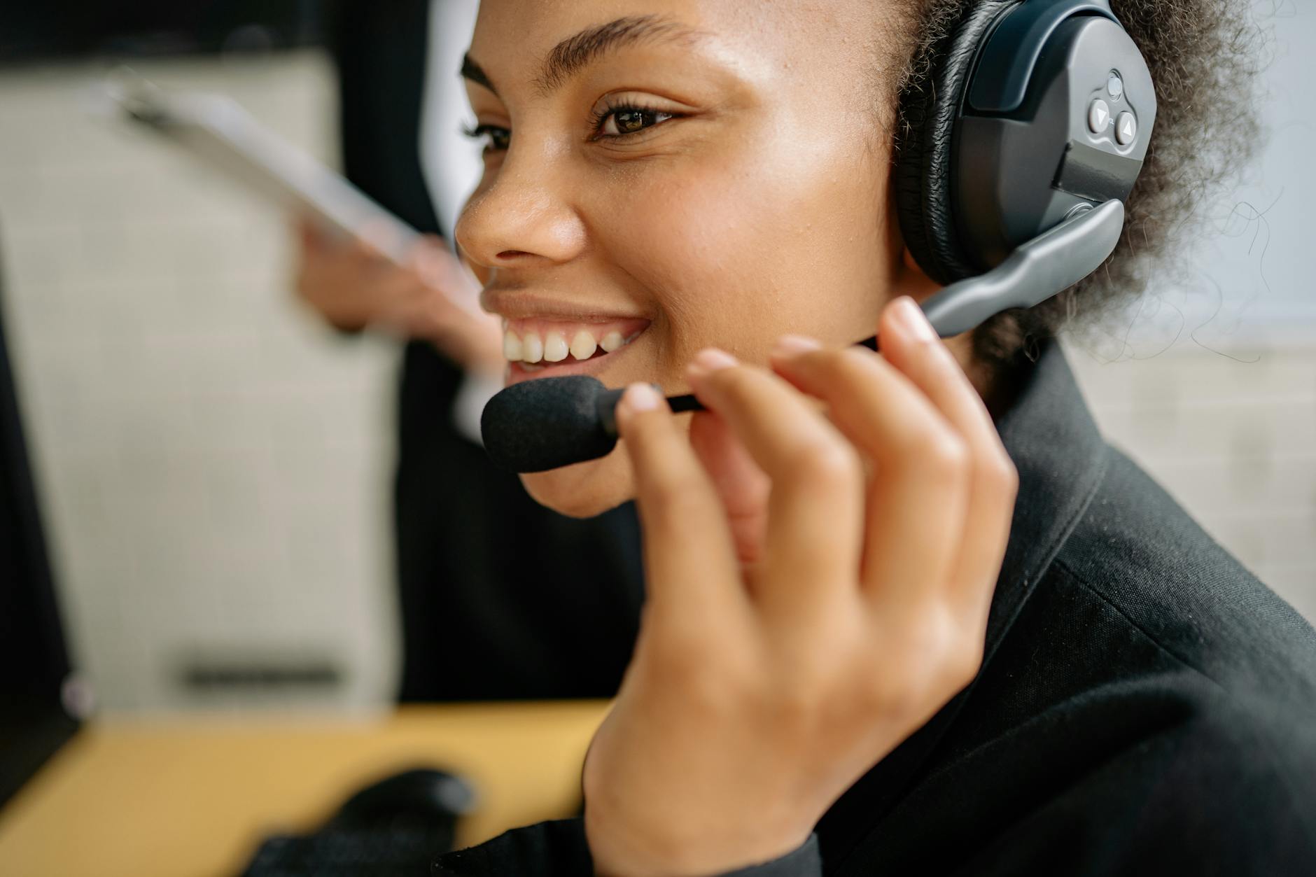 Customer service representative wearing headset working at computer desk