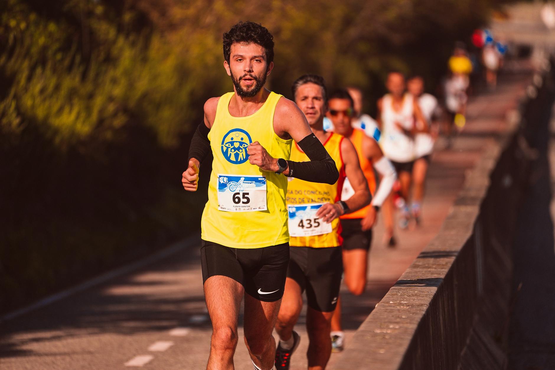 Runner checking smartwatch during training session on outdoor track or trail