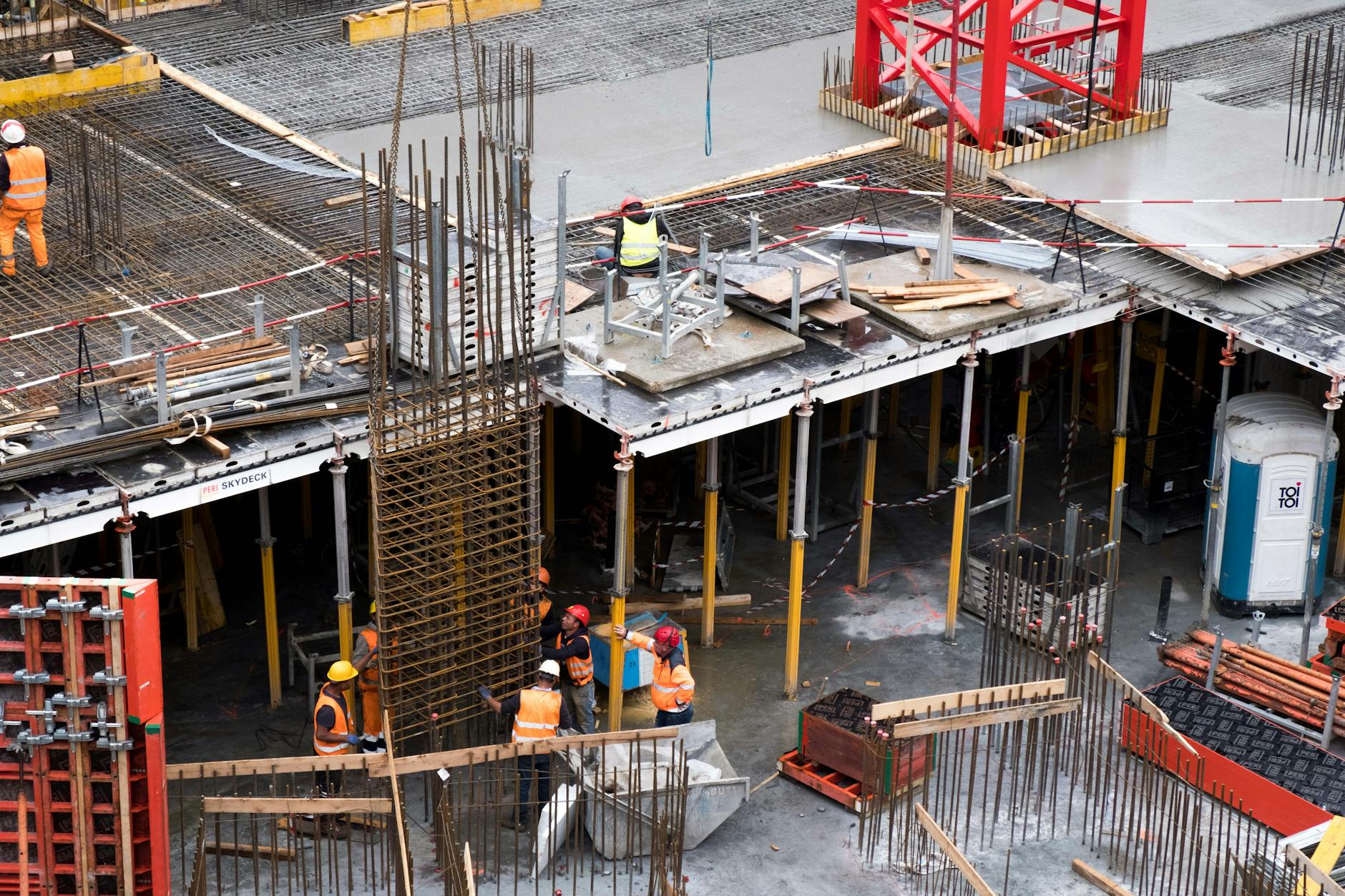 Construction workers at an excavation site with heavy machinery and earth moving equipment