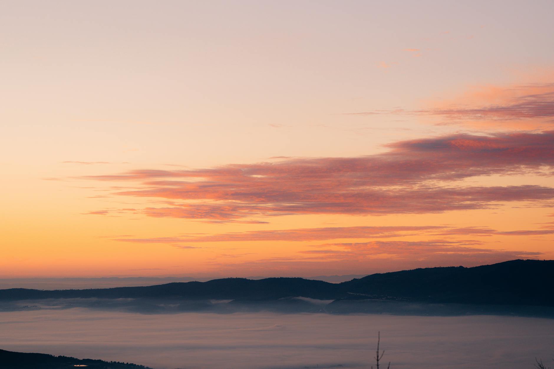 Sunrise view from mountain peak with hiking gear in foreground