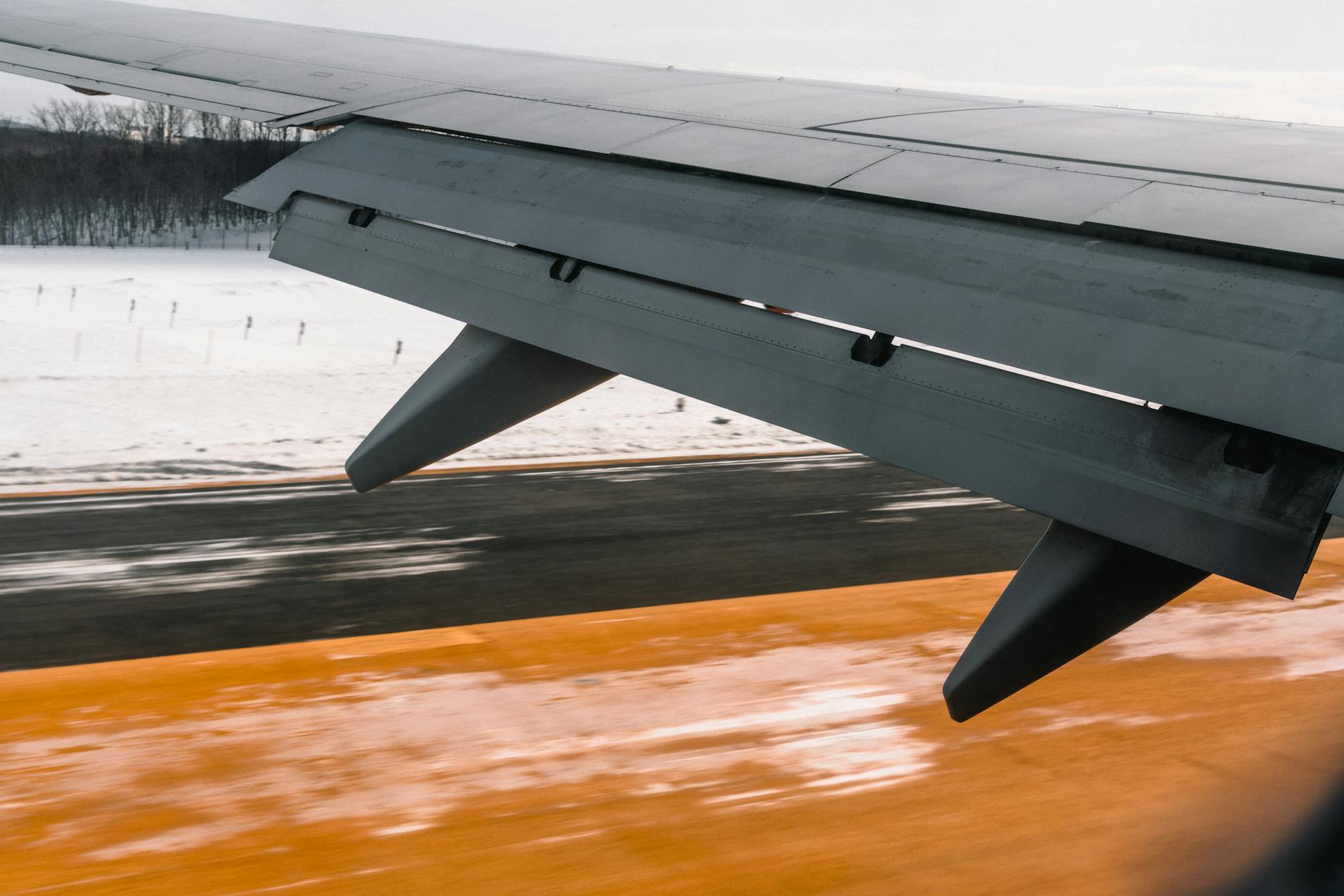 Commercial aircraft wing viewed from passenger window during flight