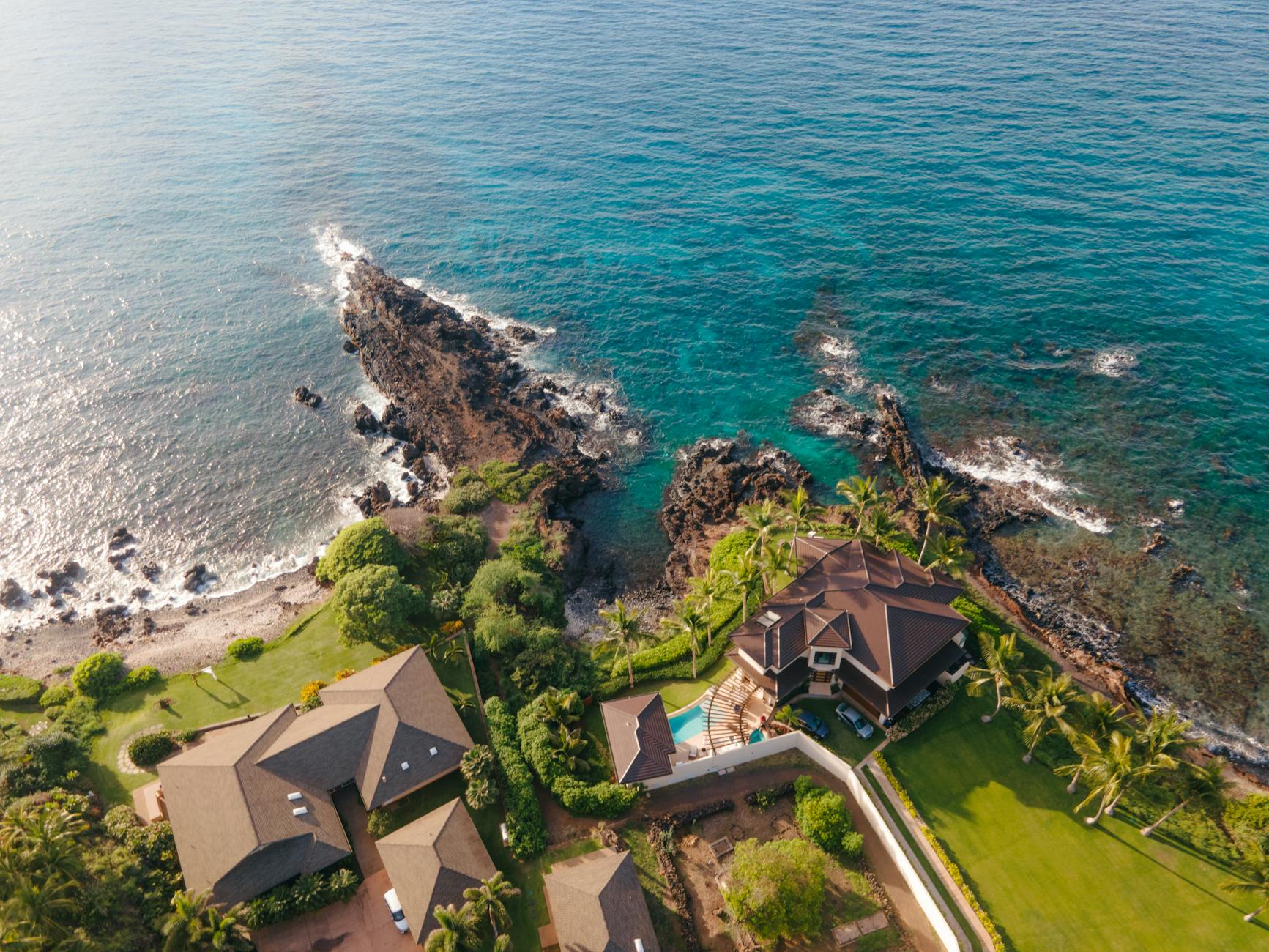 Stunning aerial view of modern luxury home with swimming pool and landscaped grounds