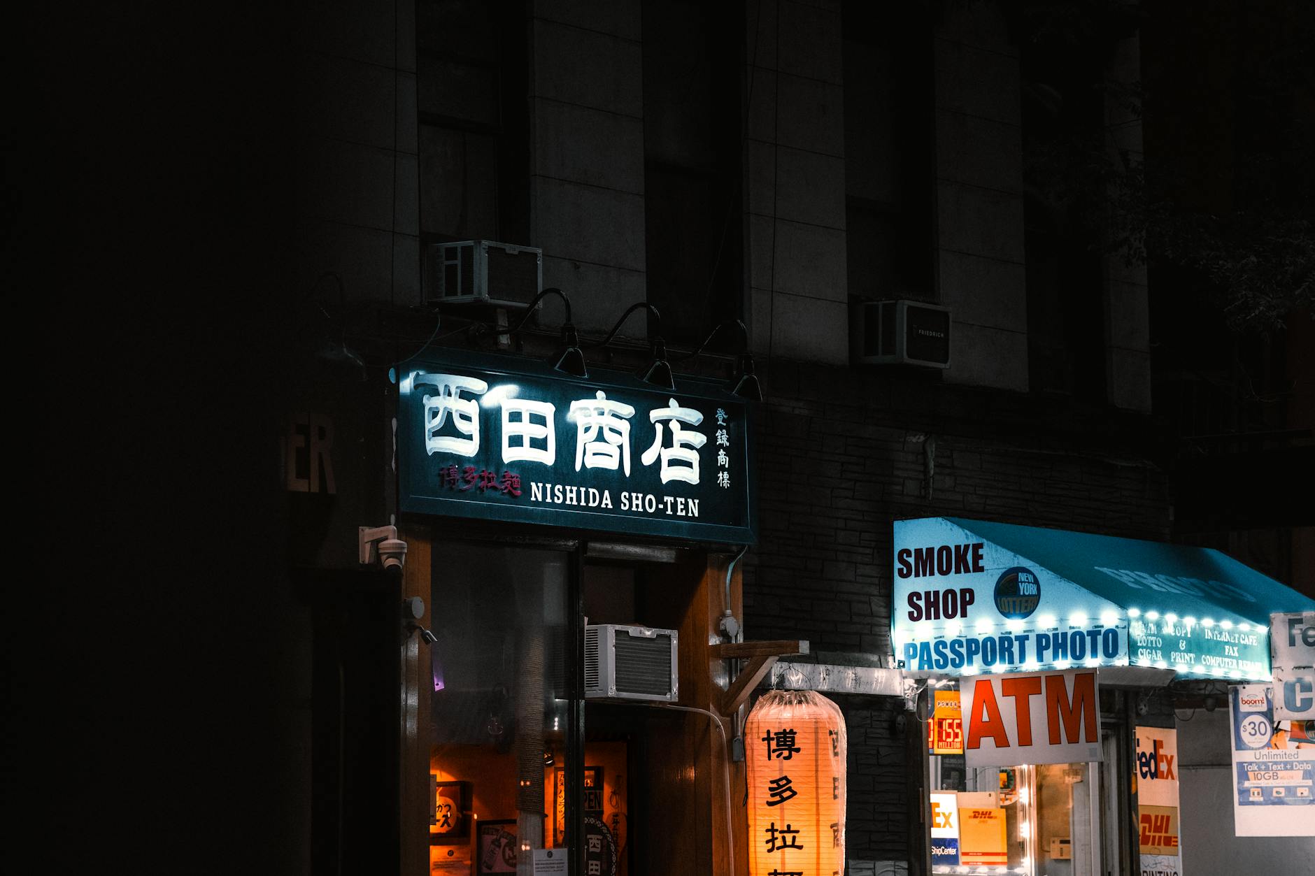 Small urban storefront with modern glass facade in busy commercial district