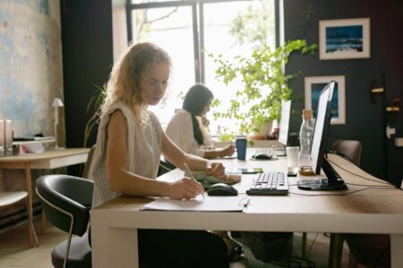 GM Cuts Hundreds from IT Workforce in AI Skills Overhaul IT professionals working at computer workstations in modern office environment