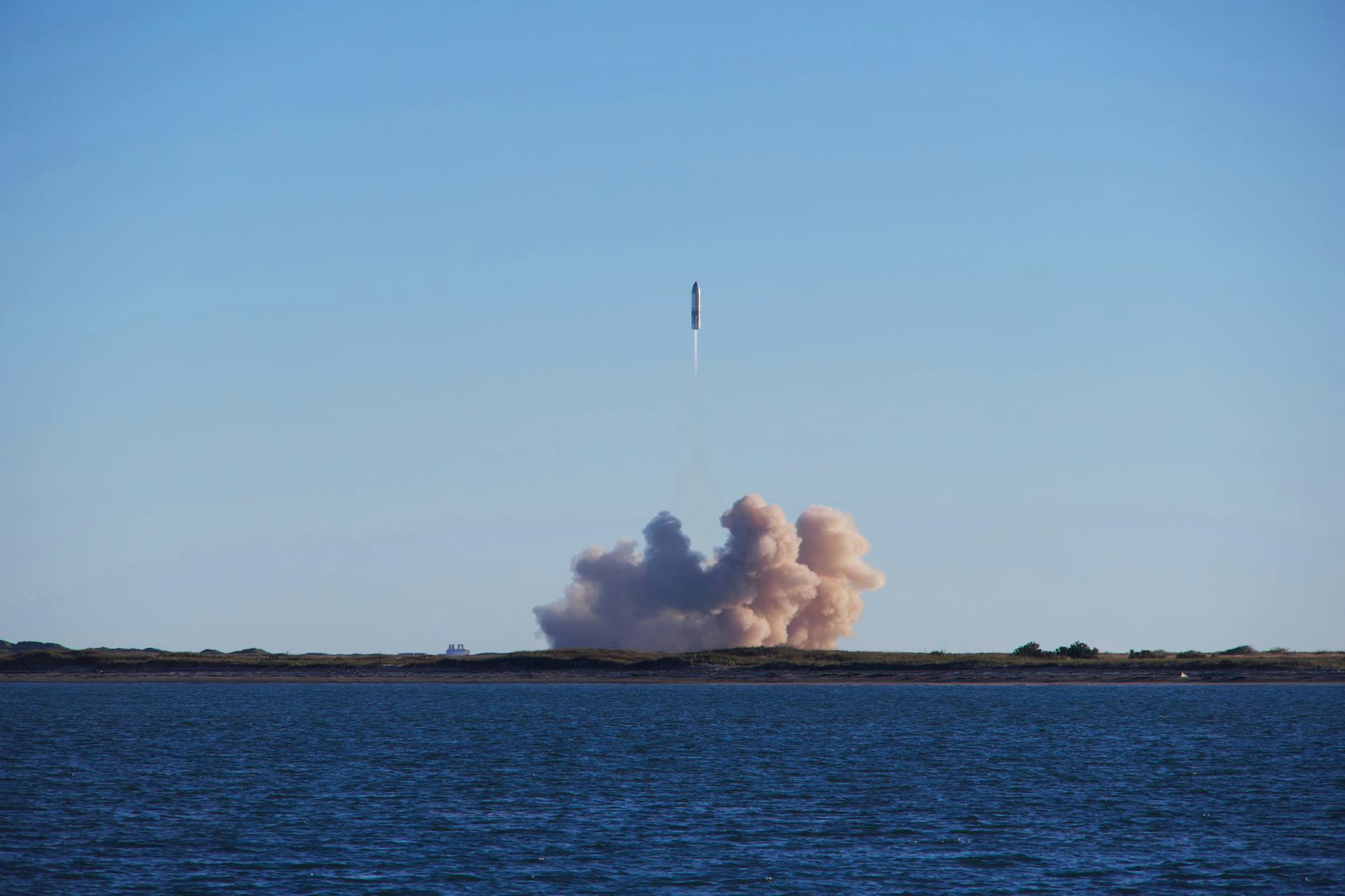 Rocket launching into space against blue sky
