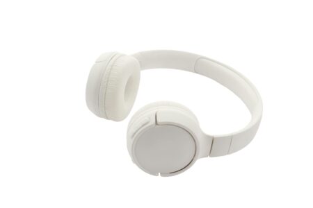 Modern wireless headphones on desk with smartphone