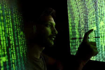 Computer screens displaying cybersecurity monitoring dashboards and network analysis