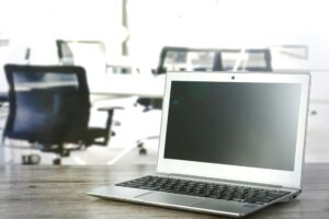 Modern laptop computer open on wooden desk workspace