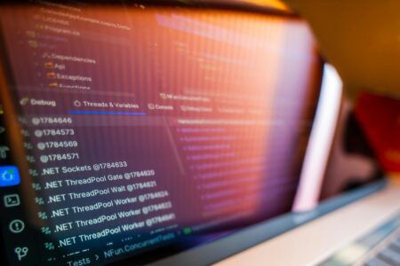 Traditional Security Models Collapse Under AI Development Pressure Developer working on code displayed on multiple computer monitors