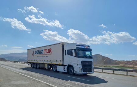 Commercial delivery truck driving on city street with visible road surface