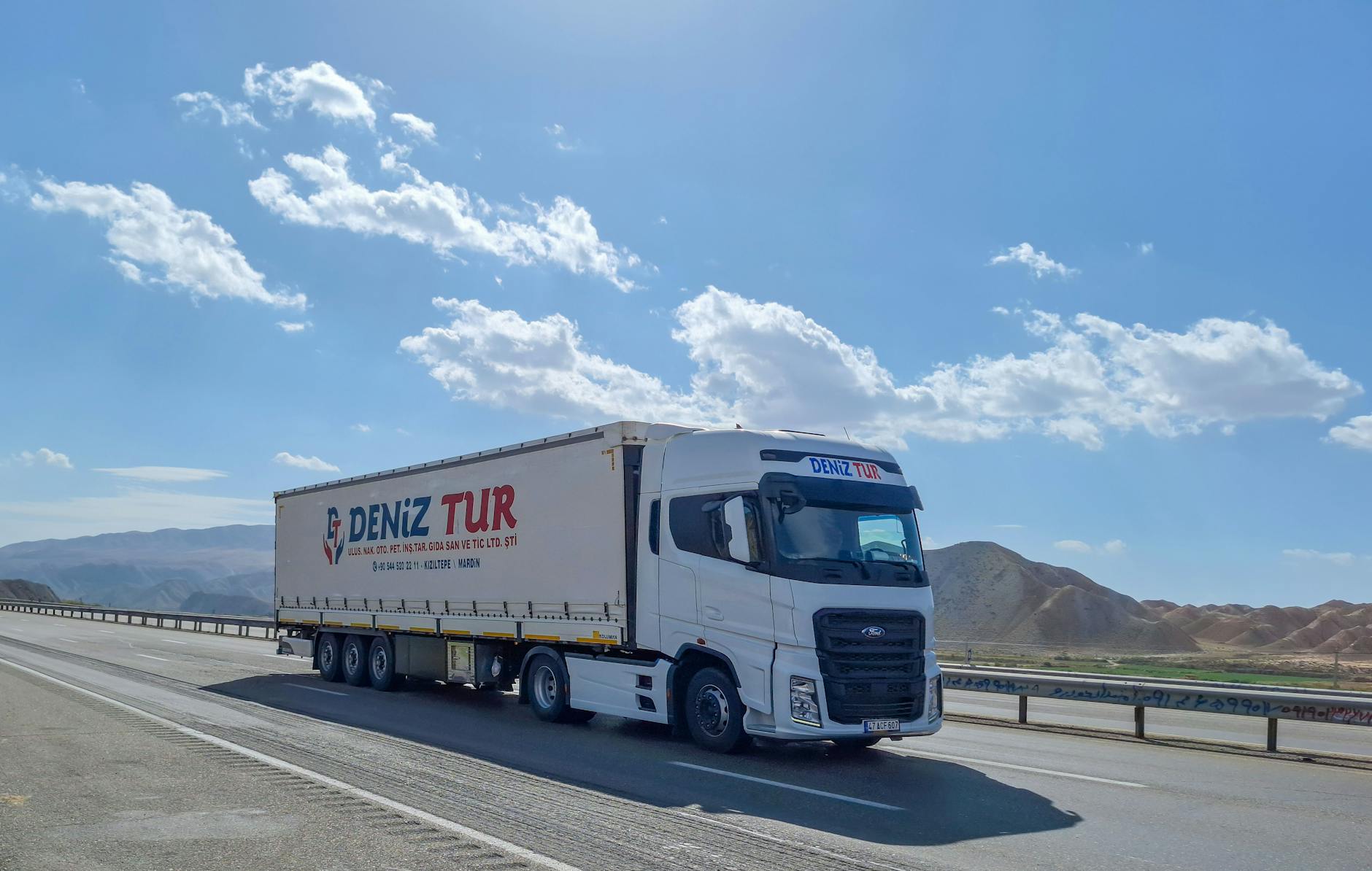 Commercial delivery truck driving on city street with visible road surface