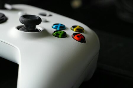Modern gaming controller on dark surface representing video game development