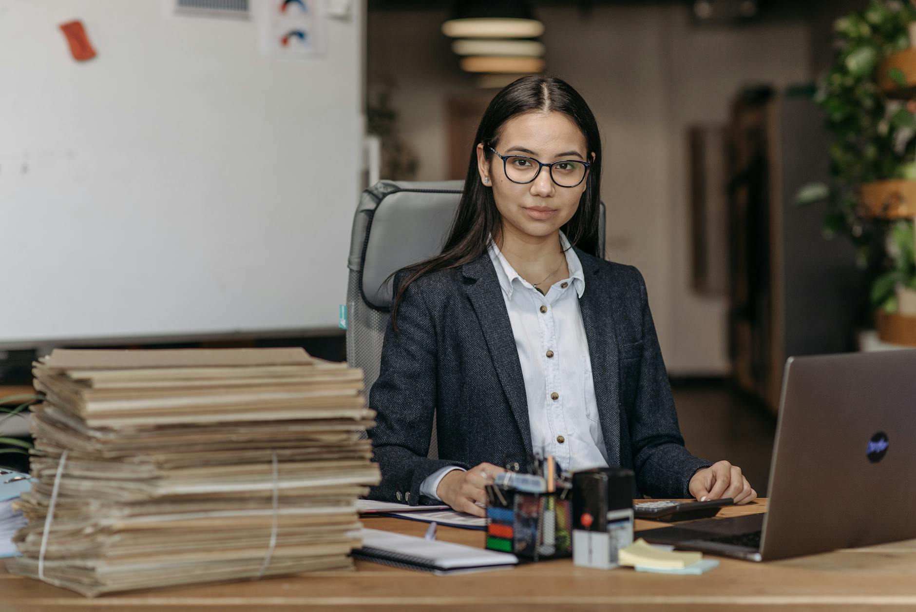 A young professional sitting at a desk looking at a laptop, representing early-career job searching