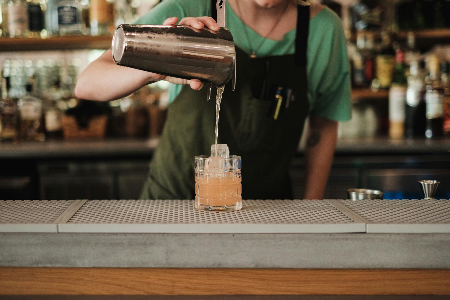 Bartender preparing cocktails with various ingredients and tools