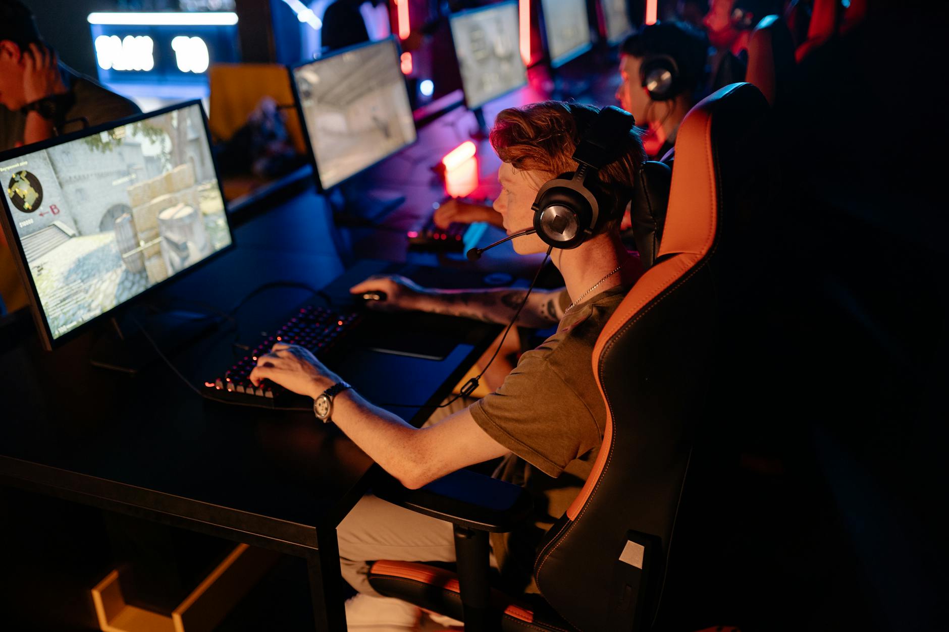 Competitive gamers at a professional eSports tournament with bright screen displays