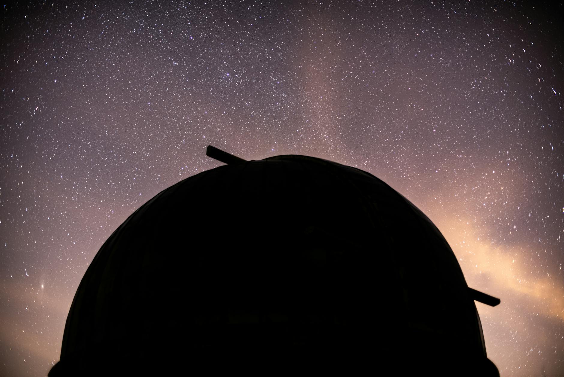 Large observatory telescope pointed toward a dark night sky