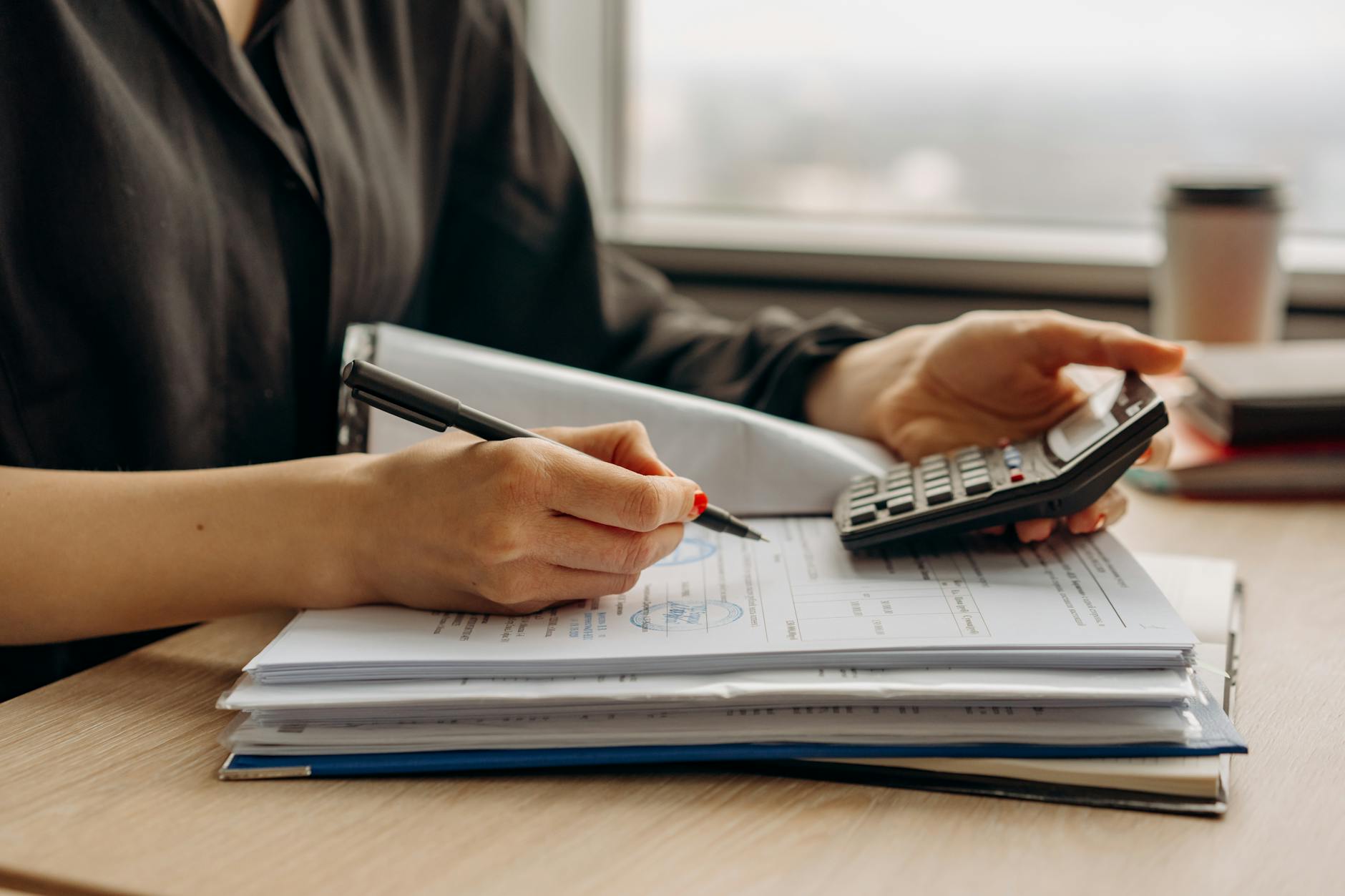 Financial documents and calculator on desk showing business analysis