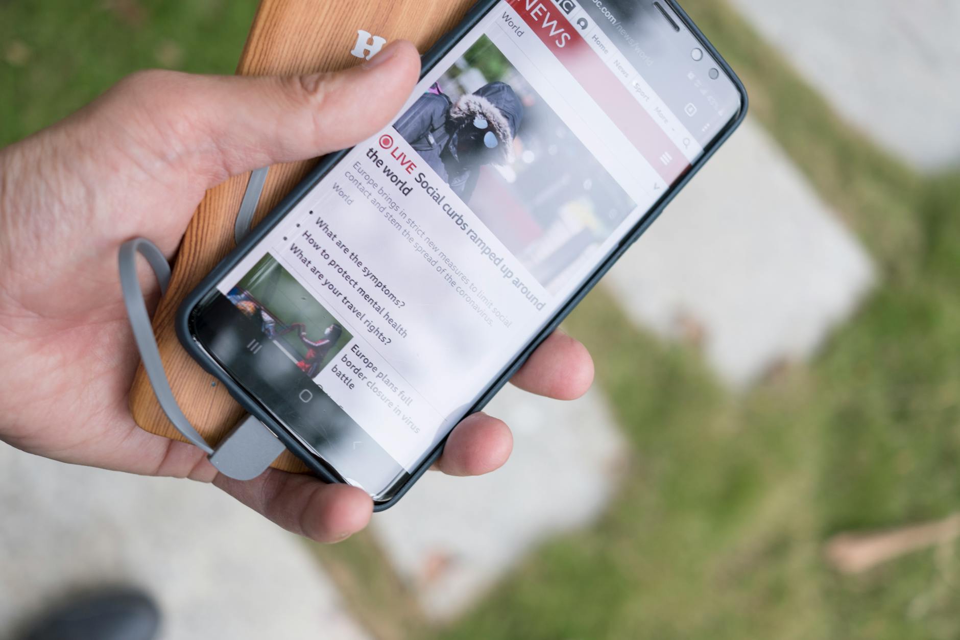 Person reading news articles on smartphone screen