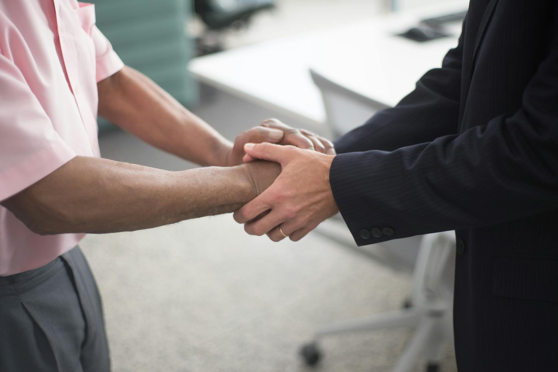 Business professionals shaking hands after closing a funding deal