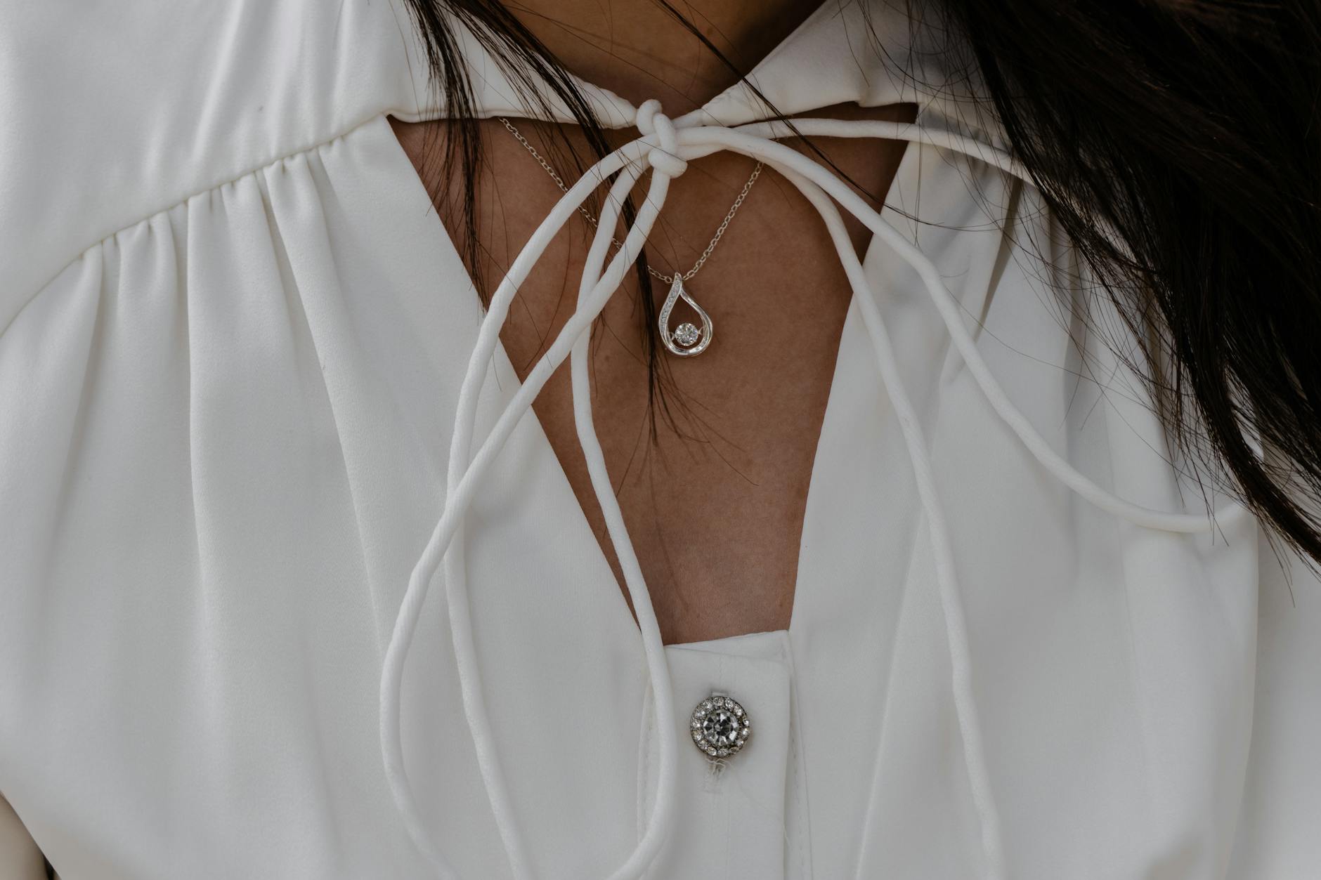 Minimalist pendant accessory worn around a person's neck