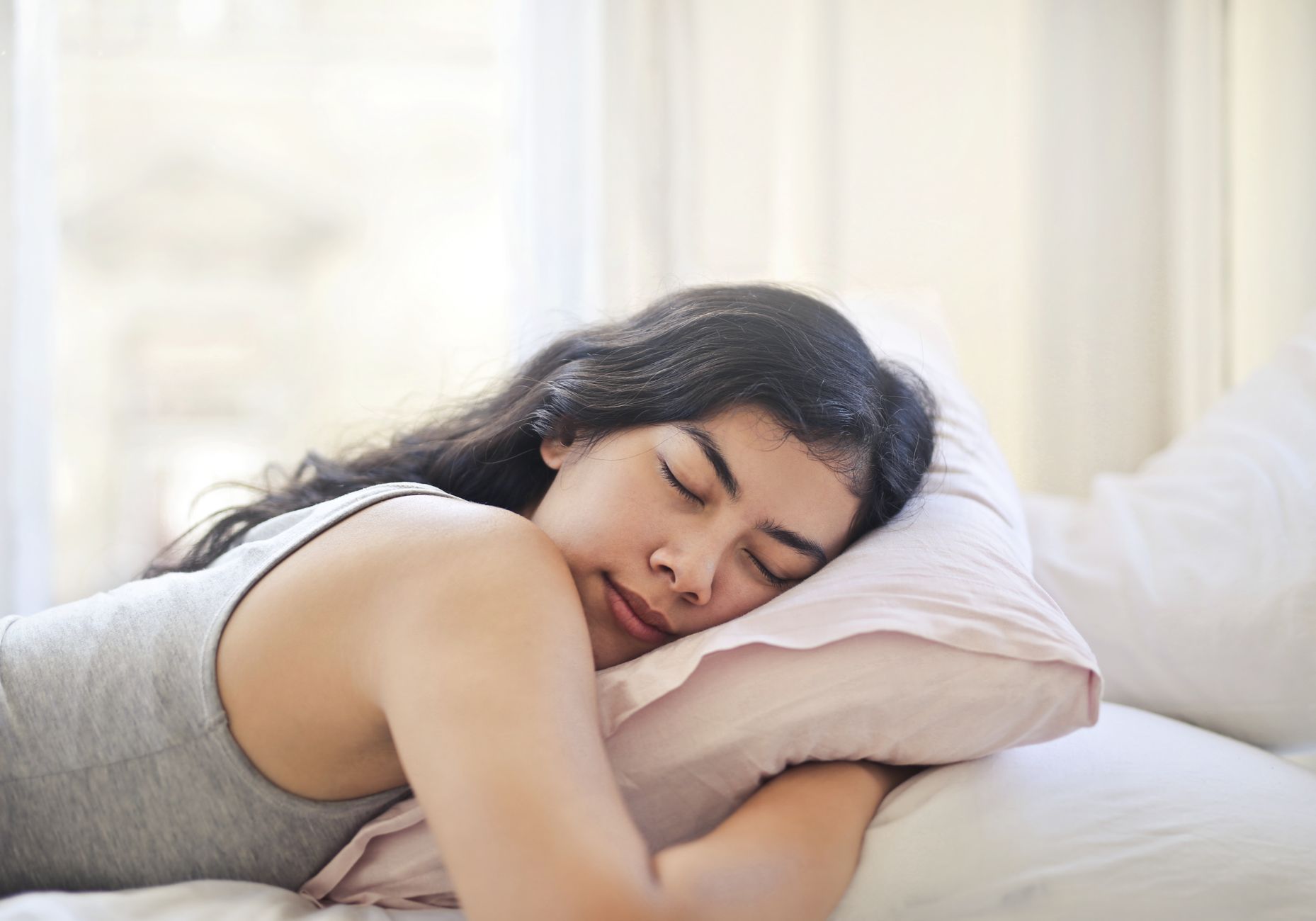 Person sleeping on their side with a pillow, representing nighttime sleep habits