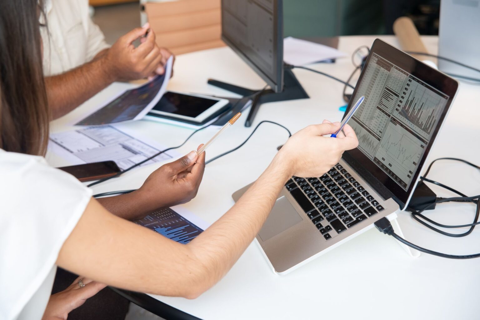 Business professionals reviewing AI software spending data on laptops in a modern office