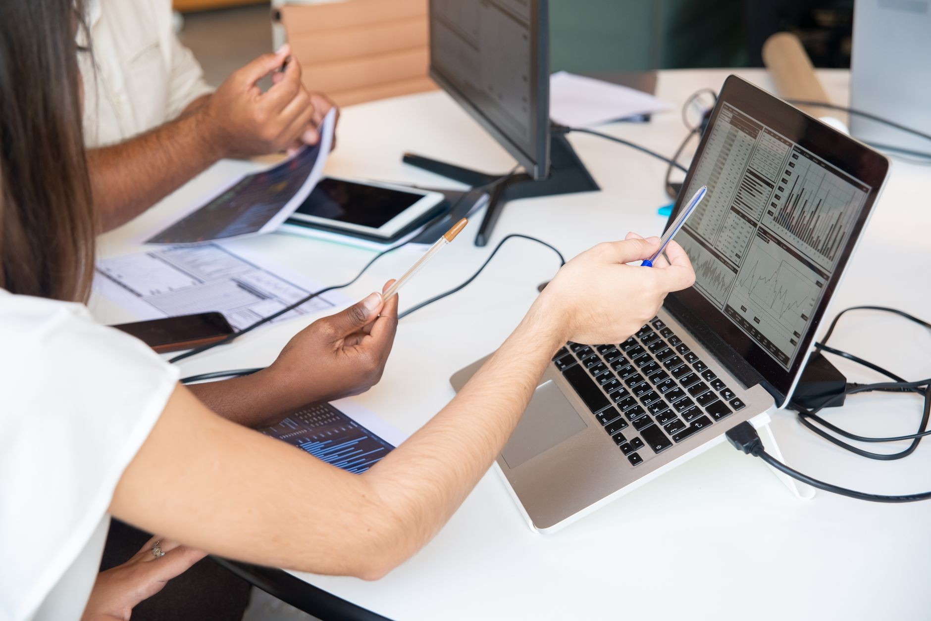 Business professionals reviewing AI software spending data on laptops in a modern office
