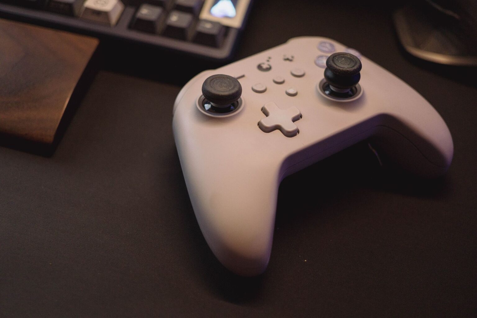 Valve Warns Some Steam Controller Orders A gaming controller resting on a desk next to a PC setup