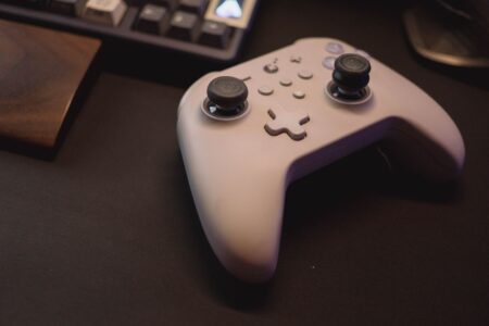 Valve Warns Some Steam Controller Orders A gaming controller resting on a desk next to a PC setup
