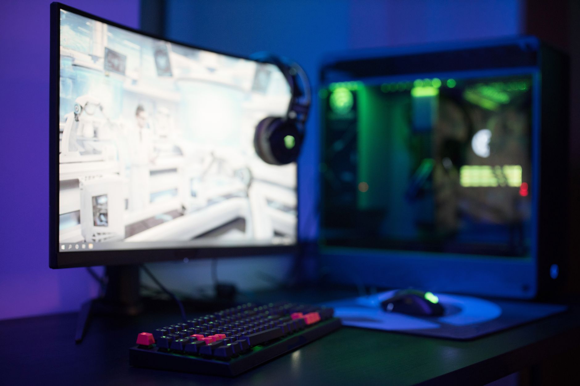 A gaming PC desktop setup with keyboard and monitor showing a game launcher interface