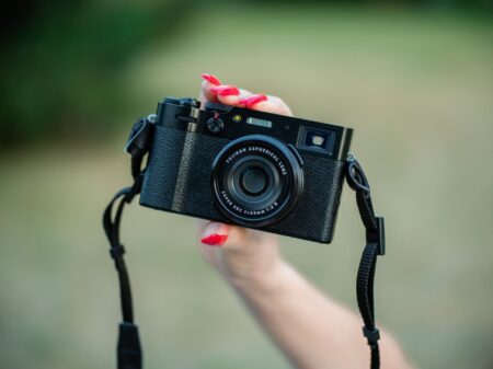 Person holding a small compact video camera while shooting outdoors