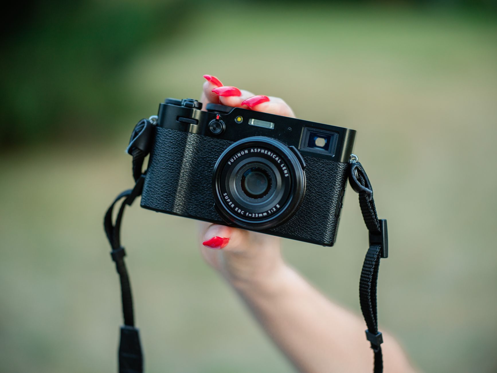 Person holding a small compact video camera while shooting outdoors