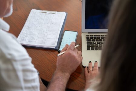 Calling AI Agents Employees Makes Human Workers Worse at Their Jobs Manager reviewing work on a computer screen in a modern office setting