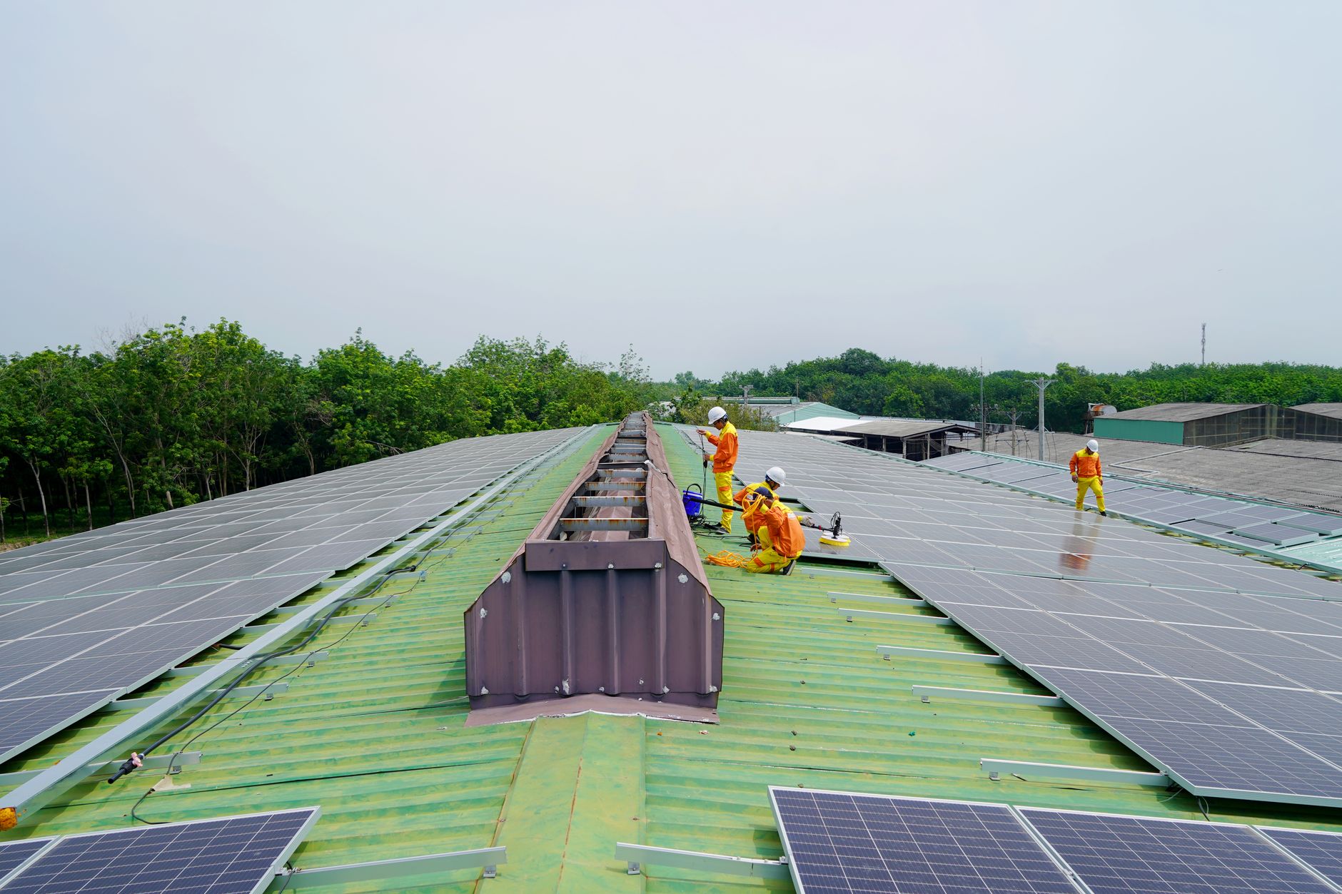 Workers at an energy construction site with equipment and open landscape in background