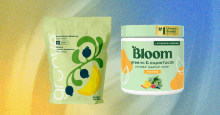 Bloom Nutrition Leads the Pack Among Best Greens Powders A scoop of green superfood powder next to a glass of water on a kitchen counter