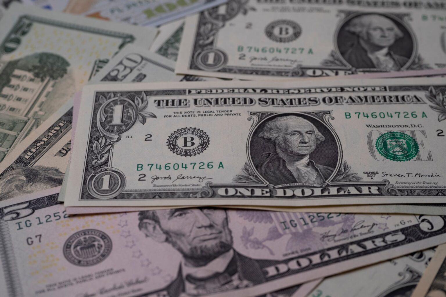 The Download: your stake in OpenAI, and the Treasury’s AI warning Stack of US dollar bills representing government financial stakes and AI dividend proposals