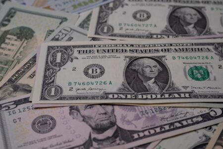The Download: your stake in OpenAI, and the Treasury’s AI warning Stack of US dollar bills representing government financial stakes and AI dividend proposals