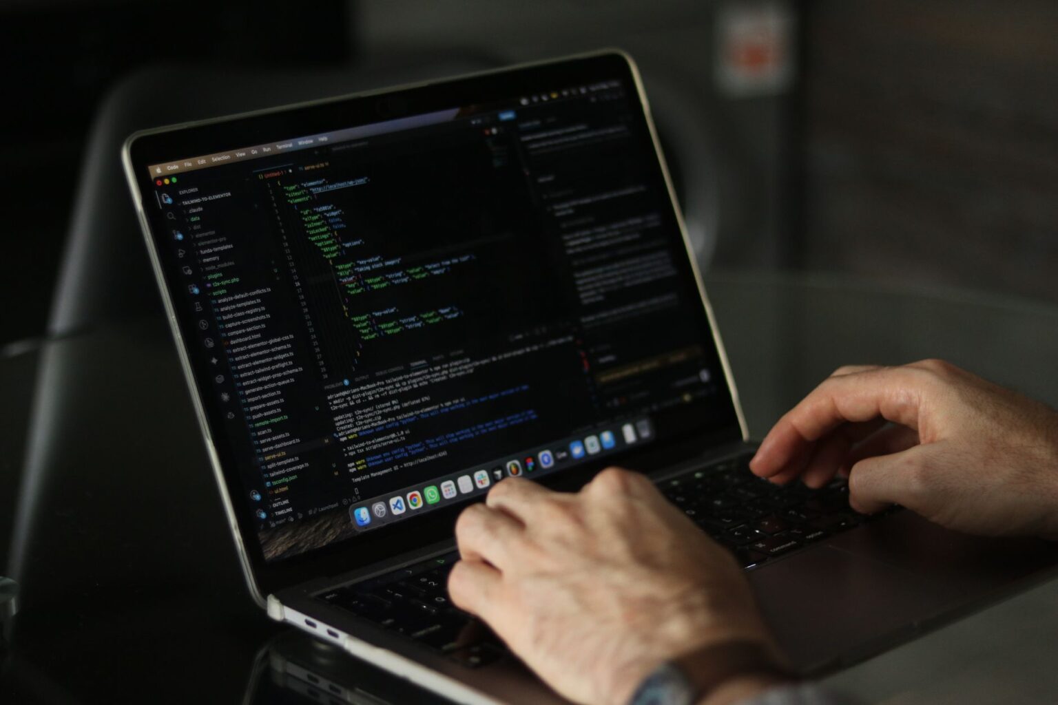 Developer working on a laptop with code on screen