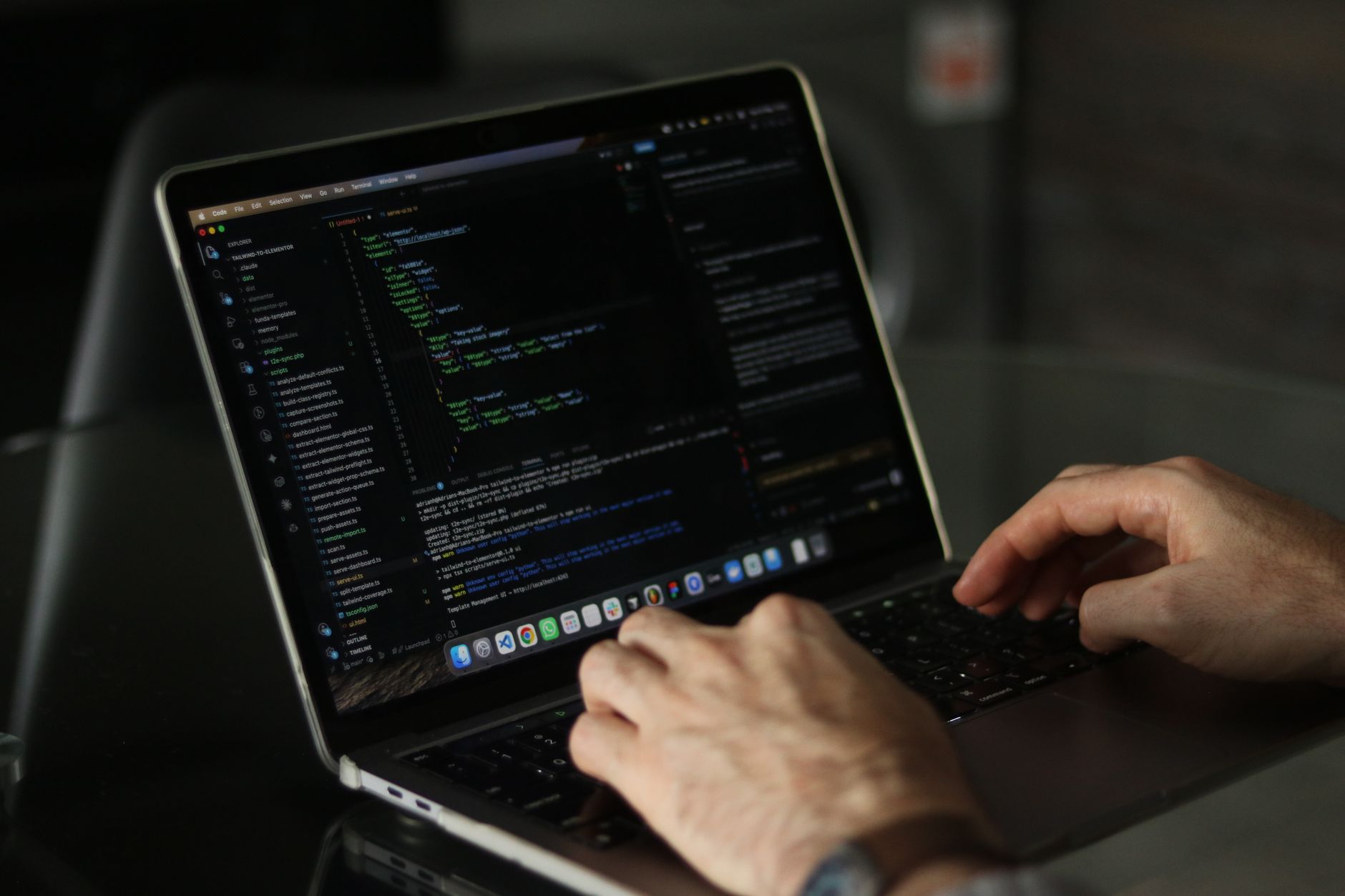 Developer working on a laptop with code on screen