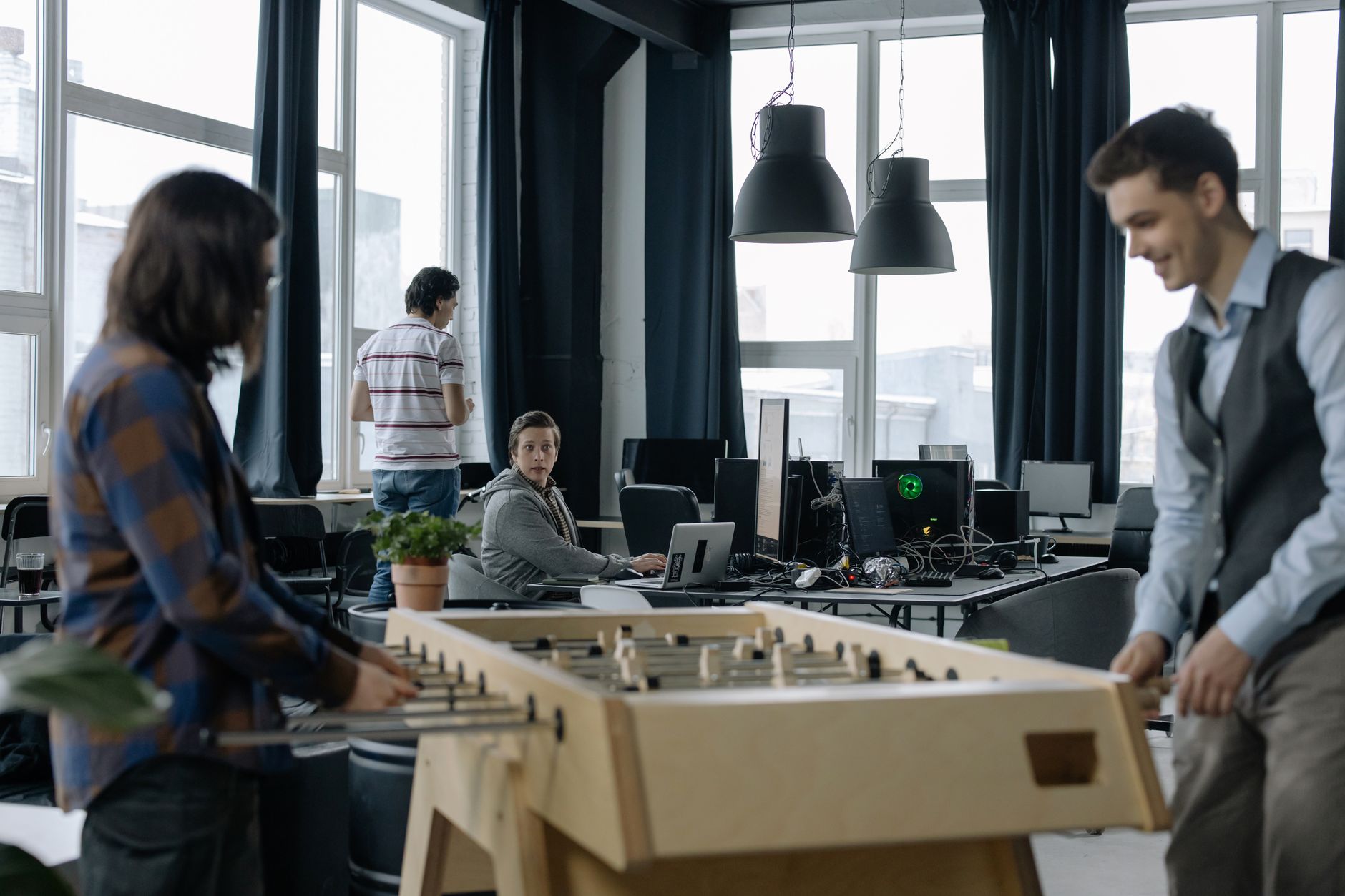 Professionals working in a modern startup office, illustrating the operational restructuring approach Bending Spoons applies to acquired companies