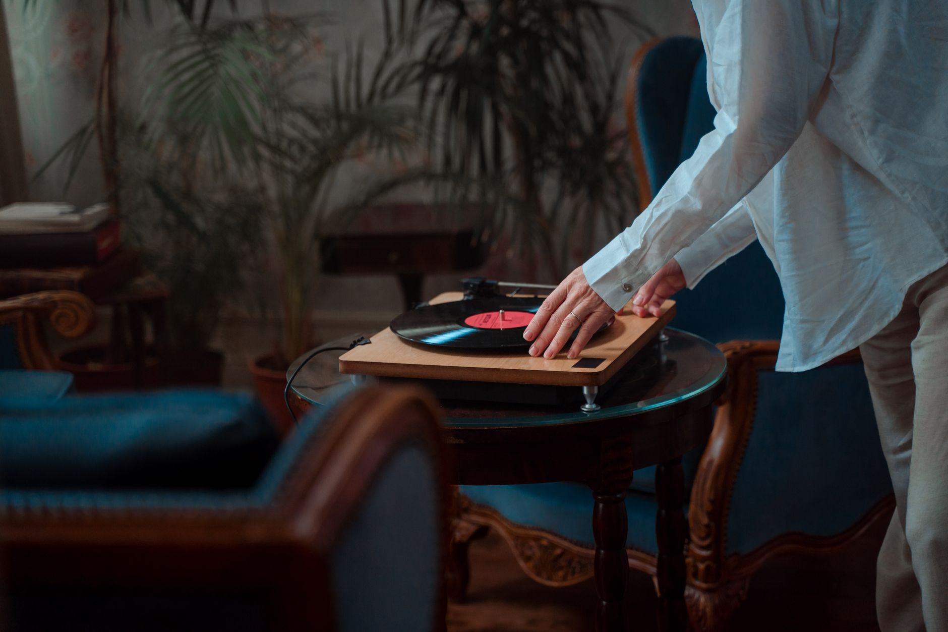 Person listening to music in a living room with audio equipment