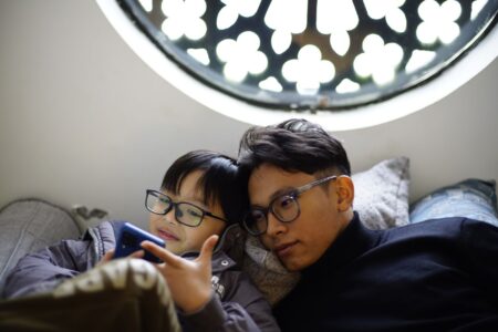 Child Surveillance Apps Scan Billions of Texts — at a Cost Parent and child looking at a smartphone together at home